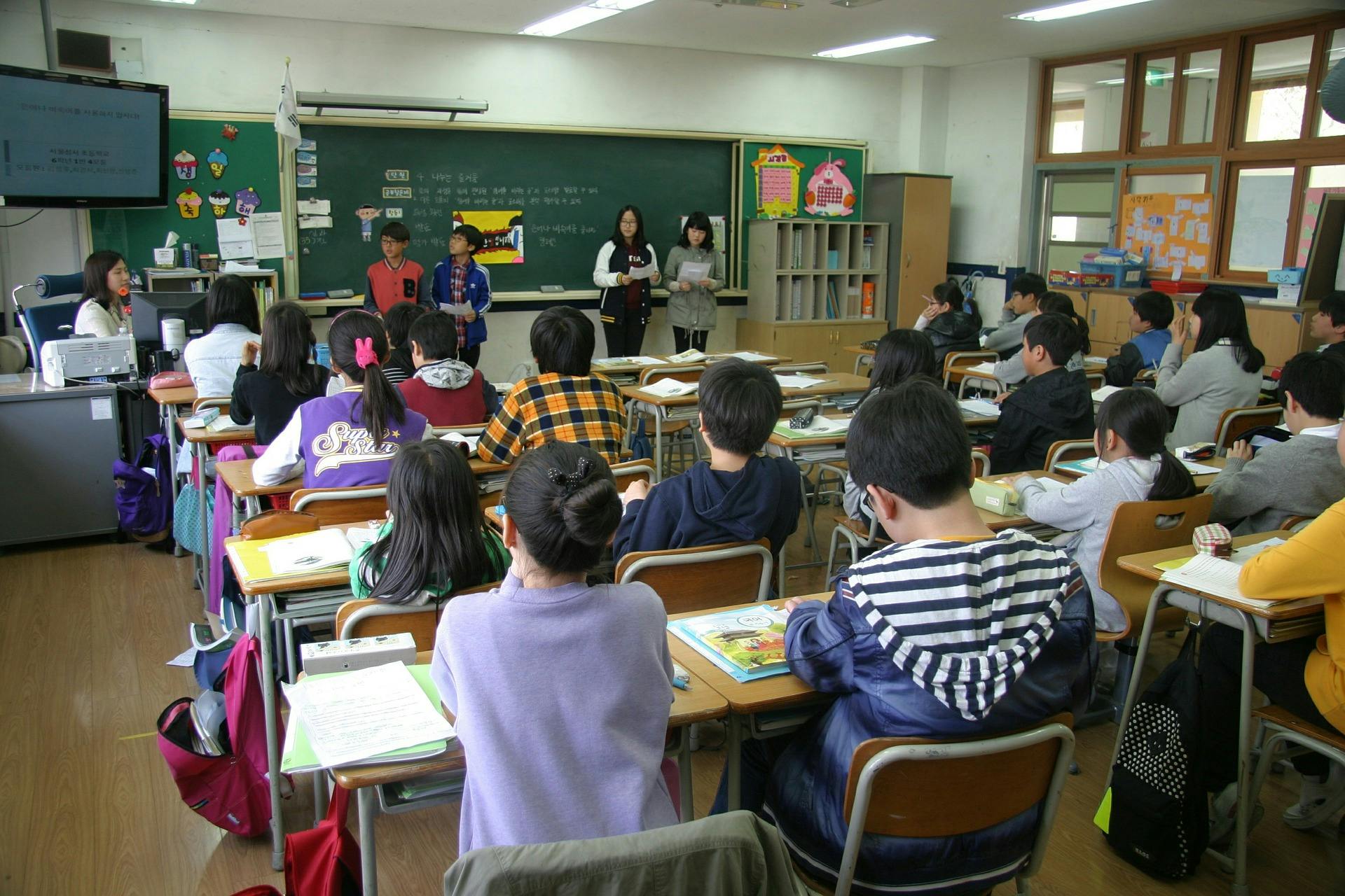 Students sit in a classroom and learn through reciprocal teaching strategies.