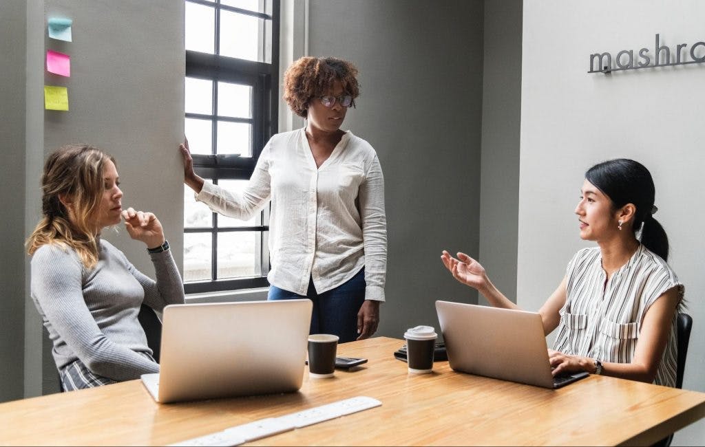 Three teachers are discussing classroom rules in a meeting room