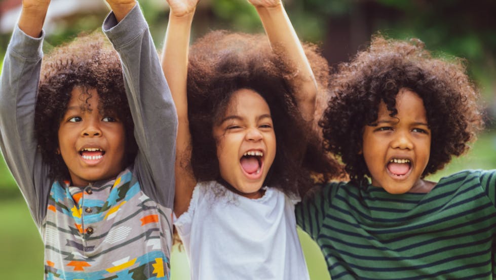 Three happy kids cheer while having fun. 