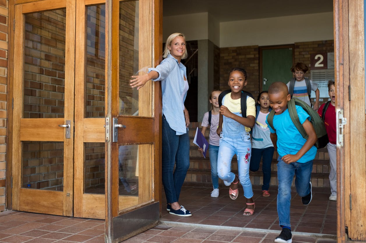 Elementary school students running out of their school for summer break.