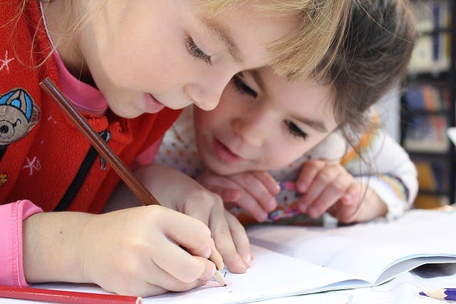 Two students solve 2nd grade math questions together.