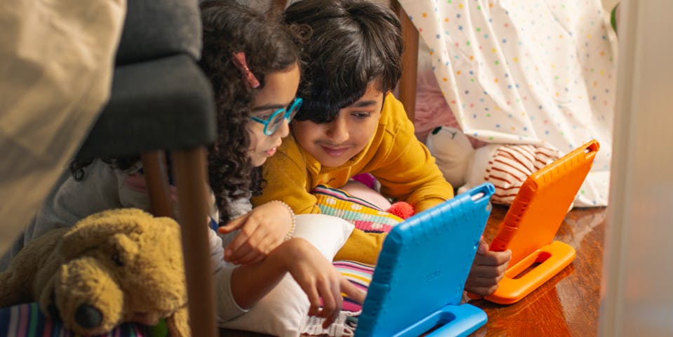 Two children play Prodigy on their tablets.