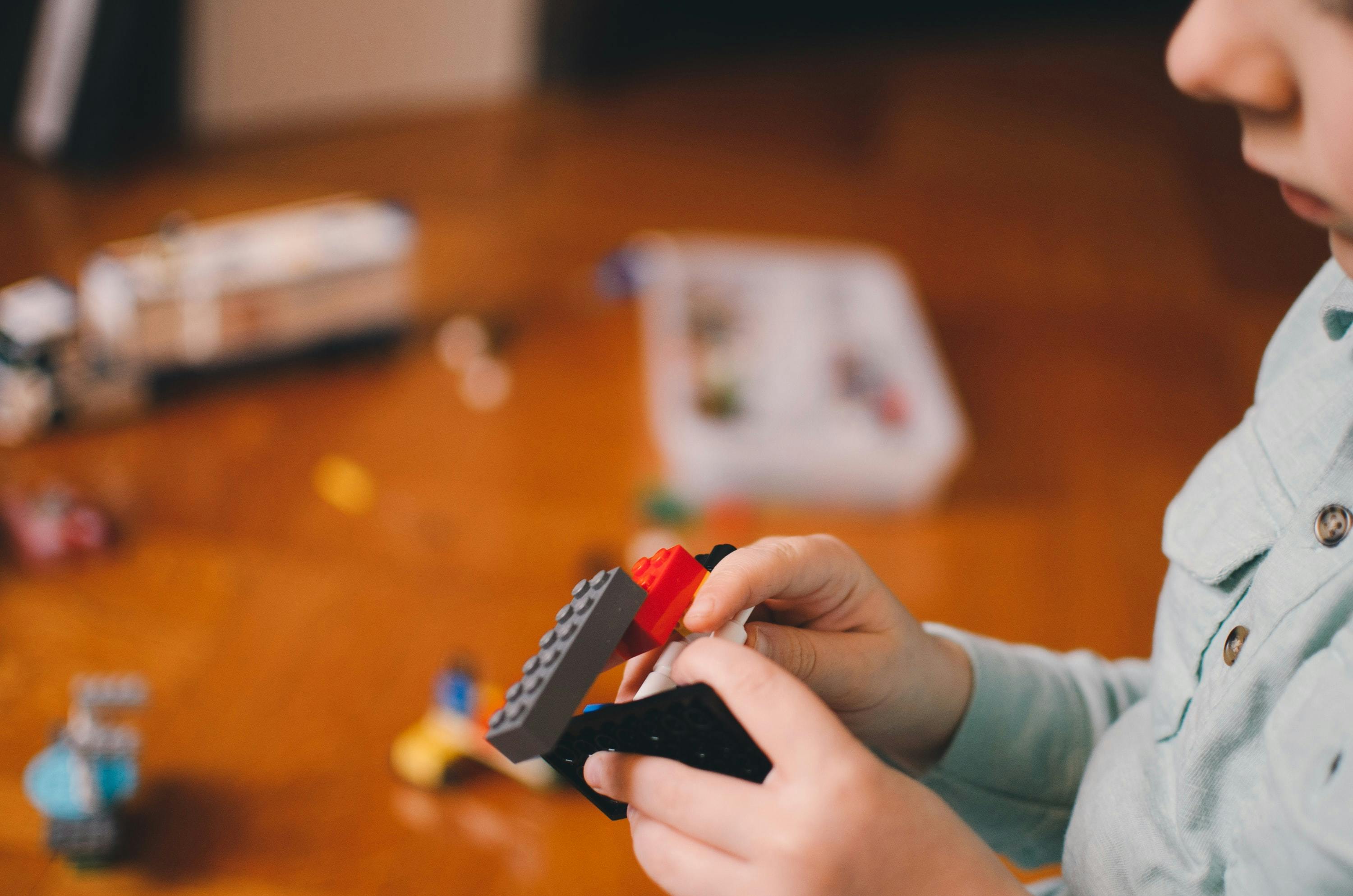 A young child plays with lego, a popular and traditional example of game-based learning.