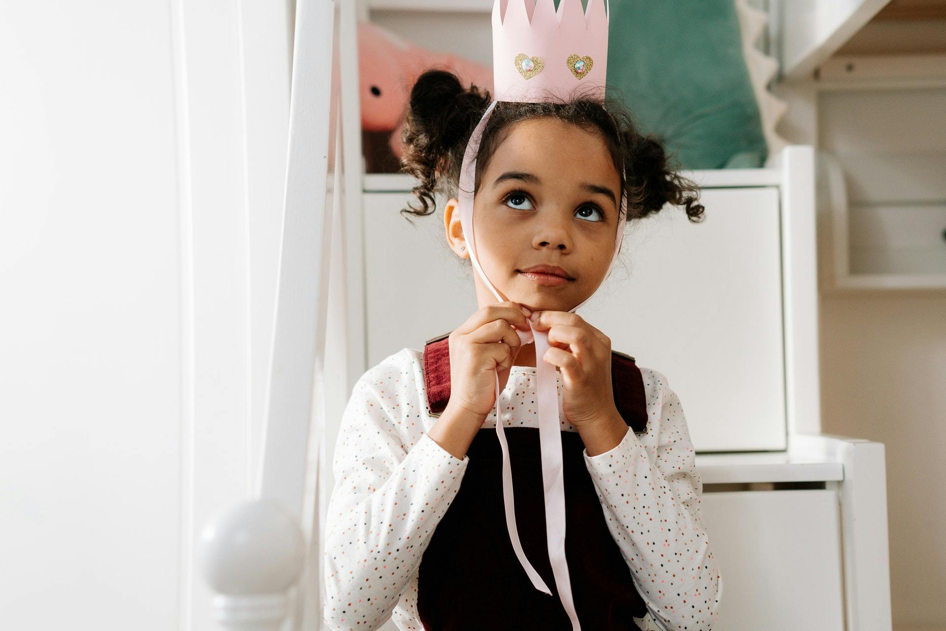 A young female kindergarten student plays dress up during play based learning activities.