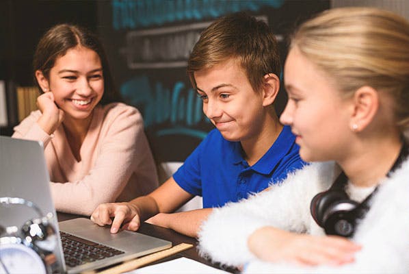 Three elementary students work in a project-based learning task.