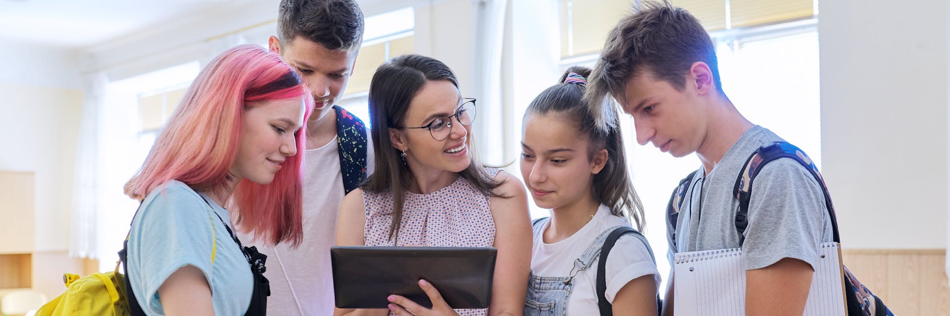 Teacher showing students educational content on tablet.