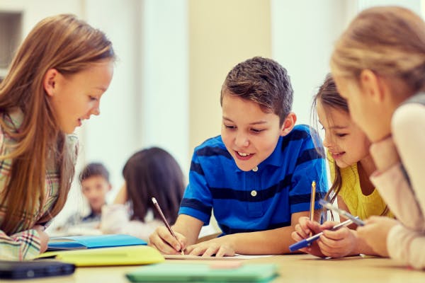 Students with pencils and notebooks work together.