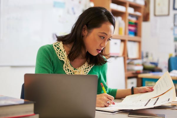 Teacher sitting at her desk and grading work.