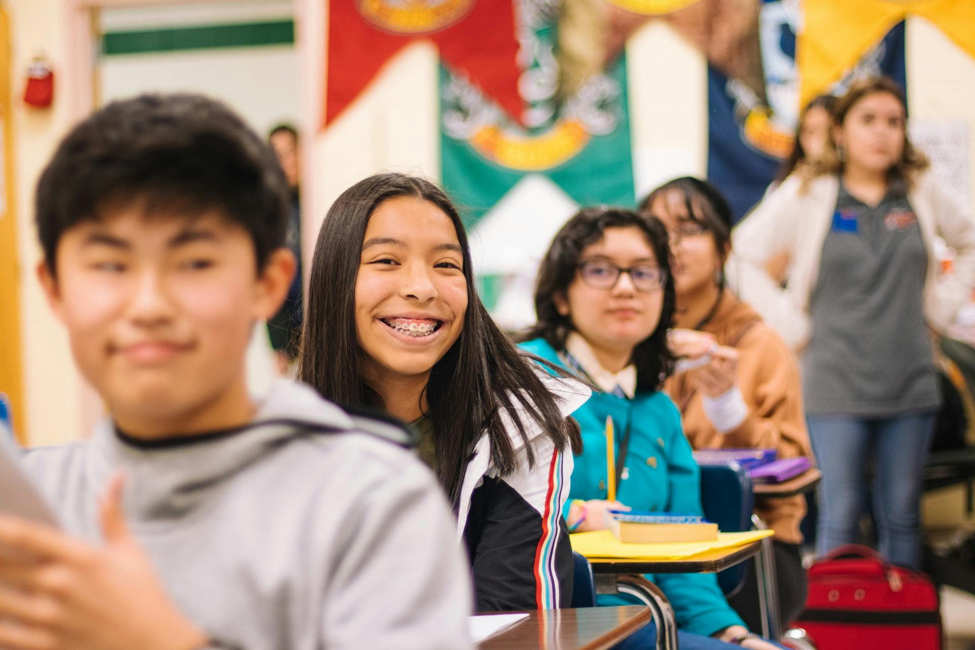 Group of students sit in their desks while one smiles because of a positive learning environment.